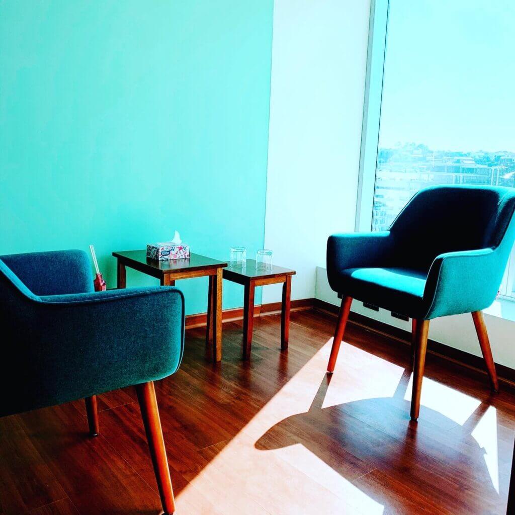 Consulta 2 con sillones azules junto a una ventana con luz natural